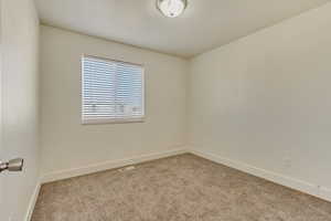 Unfurnished room featuring light carpet, visible vents, and baseboards