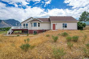 Rear view of house with a deck with mountain view and stairway