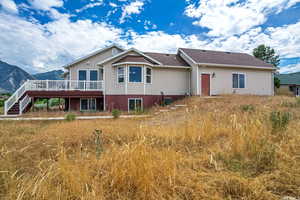 Back of house featuring a deck with mountain view and stairway