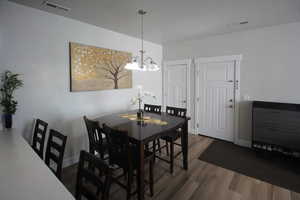 Dining space featuring an inviting chandelier and dark hardwood / wood-style flooring