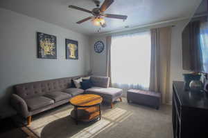 Living room featuring carpet flooring and ceiling fan