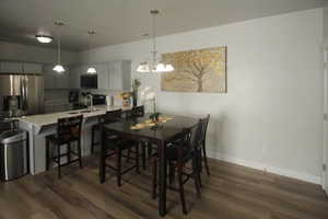 Dining space featuring sink, dark hardwood / wood-style floors, and an inviting chandelier