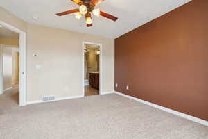 Carpeted empty room featuring ceiling fan