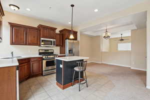 Kitchen featuring appliances with stainless steel finishes, a kitchen breakfast bar, pendant lighting, a center island, and sink