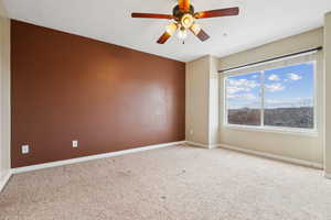 Empty room with ceiling fan and carpet floors