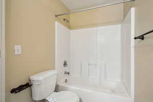 Bathroom featuring toilet and shower / bath combination