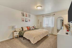 Bedroom featuring light carpet and baseboards