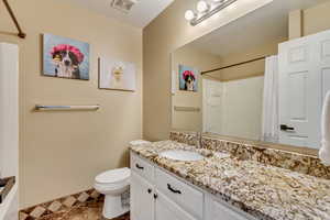 Bathroom featuring curtained shower, toilet, vanity, visible vents, and baseboards