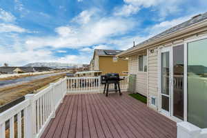 Wooden terrace featuring a grill and a mountain view