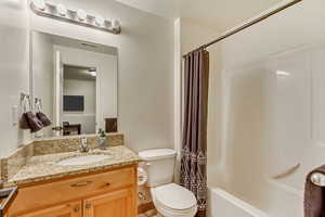 Full bath featuring visible vents, toilet, vanity, and shower / tub combo with curtain