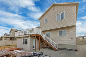 Rear view of property featuring a patio area, stairs, fence, and a deck