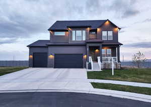 View of front of home featuring a porch, fence, a front lawn, concrete driveway, and an attached garage