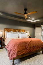 Bedroom with ceiling fan, carpet floors, a raised ceiling, and recessed lighting