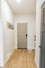 Entryway featuring light wood-style floors, baseboards, and visible vents