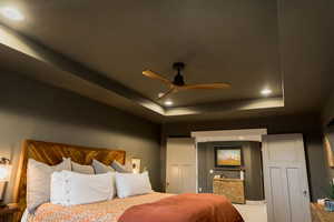 Bedroom featuring a tray ceiling and recessed lighting