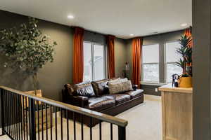 Living room featuring carpet floors, recessed lighting, visible vents, and baseboards