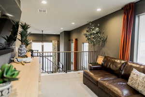 Living room featuring recessed lighting, visible vents, and carpet flooring