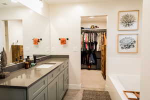 Full bathroom featuring visible vents, a garden tub, and vanity