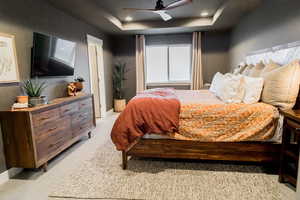 Bedroom featuring a tray ceiling, recessed lighting, light colored carpet, ceiling fan, and baseboards