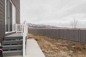 View of yard with a deck with mountain view and a fenced backyard