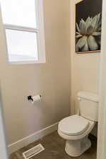 Bathroom with toilet, baseboards, and visible vents