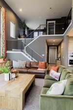 Living room with stairs and a towering ceiling