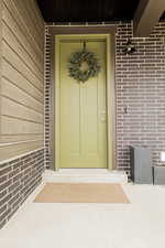 Doorway to property with brick siding