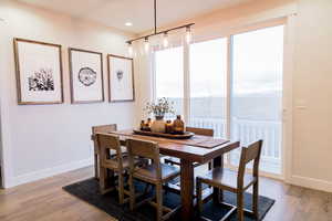 Dining space with light wood-type flooring, a water view, baseboards, and recessed lighting