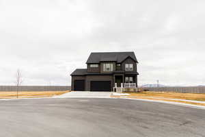 View of front of property featuring a garage, concrete driveway, roof with shingles, and fence