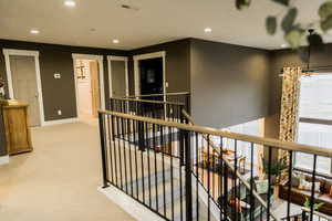 Corridor featuring recessed lighting, carpet flooring, an upstairs landing, baseboards, and visible vents