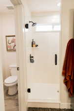 Full bath featuring a stall shower, visible vents, and toilet