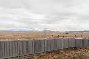 View of yard featuring a rural view, fence, and a mountain view