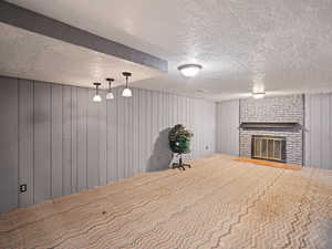 Finished basement featuring a fireplace and a textured ceiling