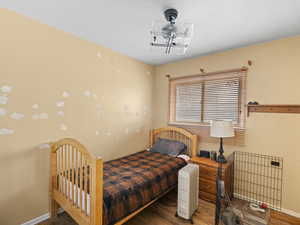 Bedroom with dark wood-type flooring and baseboards