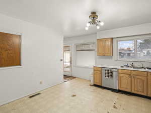 Kitchen with light floors, visible vents, light countertops, a sink, and dishwasher