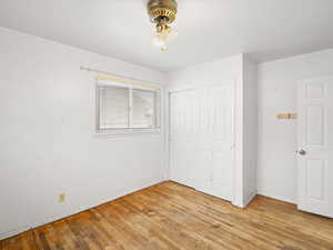 Unfurnished bedroom featuring light wood-style flooring, baseboards, and a closet