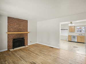 Unfurnished living room featuring light wood-style flooring, a fireplace, visible vents, and a textured ceiling