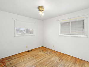 Empty room with visible vents and light wood finished floors