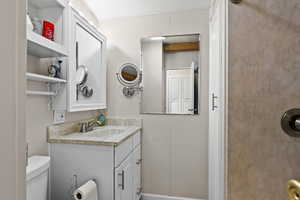 Half bathroom with vanity and toilet