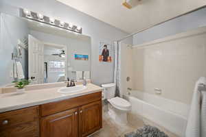 Bathroom featuring toilet, shower / bath combo, connected bathroom, vanity, and tile patterned floors