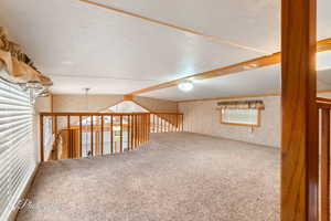 Unfurnished room featuring beam ceiling and carpet flooring