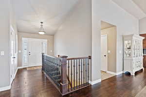 Entrance foyer with high vaulted ceiling, baseboards, and wood finished floors