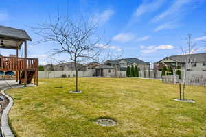 View of yard with stairs, a deck, a fenced backyard, and a residential view