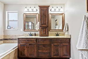 Bathroom with a garden tub, a sink, a shower stall, and double vanity