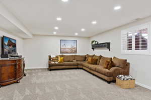 Carpeted living room with baseboards, visible vents, and recessed lighting