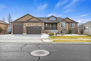 View of front of home featuring a garage, concrete driveway, fence, a front lawn, and stucco siding