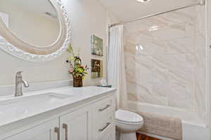 Bathroom with visible vents, vanity, shower / bath combination with curtain, and toilet