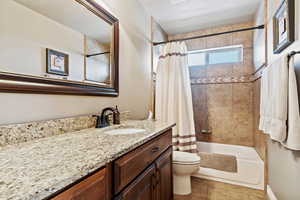 Bathroom with shower / bath combo, tile patterned flooring, vanity, and toilet