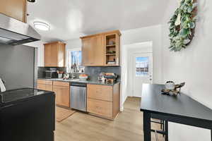 Kitchen featuring range with electric cooktop, full stone backsplash, ss dishwasher, open shelves, and ss fridge that is INCLUDED