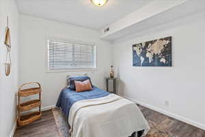 Bedroom featuring baseboards, visible vents, and dark wood-style flooring